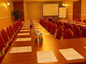 a long table in a conference room with red chairs at Hotel Jabłoński in Dorotowo