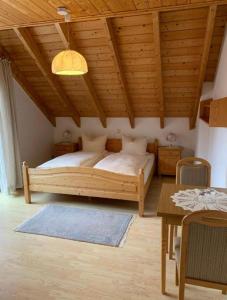 - une chambre avec un lit et un plafond en bois dans l'établissement Landhaus Schneeberg, à Mosbach