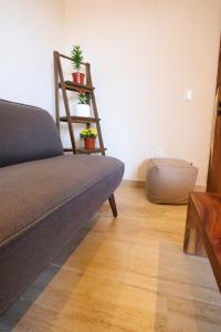 a living room with a couch and a shelf with potted plants at Akbal Tulum in Tulum