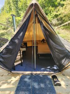 a tent with a blue rug in front of it at Glamping tent in Butler