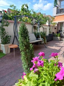 a swing in a garden with pink flowers at Kuća za odmor sa 3 spavaće sobe in Kragujevac +34 photos