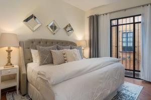 um quarto com uma grande cama branca e uma janela em Elegant 3BR Home with Rooftop & Grill in Centro San Miguel em San Miguel de Allende