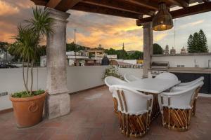 um pátio com uma mesa e cadeiras numa varanda em Elegant 3BR Home with Rooftop & Grill in Centro San Miguel em San Miguel de Allende