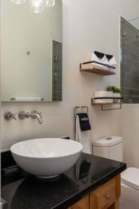 uma casa de banho com um lavatório branco e um WC. em Elegant 3BR Home with Rooftop & Grill in Centro San Miguel em San Miguel de Allende