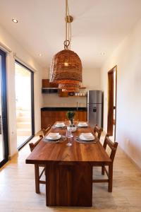 a dining room with a wooden table and a kitchen at Akbal Tulum in Tulum
