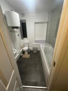 a bathroom with a tub and a toilet and a sink at Sutton Coldfield Apartment in Birmingham