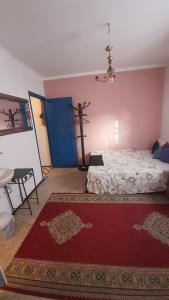 um quarto com uma cama e um tapete vermelho em Riad Khira em Agadir