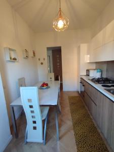 a kitchen with a white table and a white chair at La Dama dei Fiori in Vimercate