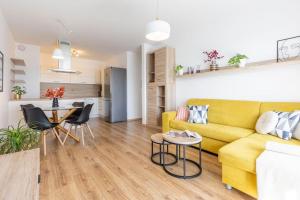 a living room with a yellow couch and a table at BNB Slovakia Slnečnice Apartment 1 in Bratislava