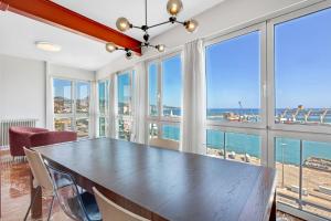 una sala da pranzo con tavolo e vista sull'oceano di Apartamento Alameda de Colon a Málaga