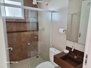 a bathroom with a shower and a toilet and a sink at Apartamento Duplex na Praia Grande 108 VISTA MAR in Arraial do Cabo +31 photos