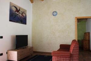 a living room with a couch and a tv at Appartamento vacanze Riccardo ed Ester in Ronzo Chienis