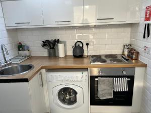 een keuken met een wasmachine en een wastafel bij Very Central, Charlotte Square, near the Castle in Edinburgh
