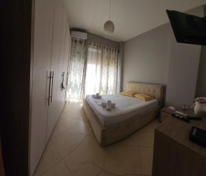 een slaapkamer met een bed en een groot raam bij D & G Apartment in Tirana