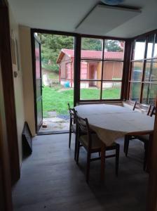 a table and chairs in a room with a large window at Lesní chaty "Hogo Fogo" in Kytlice