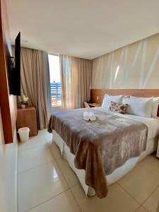 um quarto com uma cama grande com duas velas em Conde Hotel em Maceió