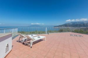 a patio with a table and a bench on a balcony at La Terrazza sul Golfo in Sorrento