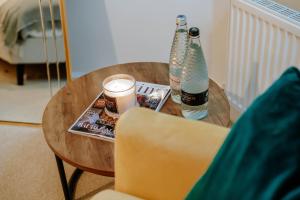 a round wooden table with two bottles and a candle at Mayfield - Central Harrogate Apartment - Ground Floor in Harrogate