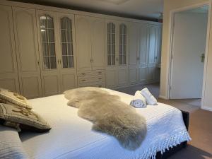 um quarto com uma cama branca com um cobertor de peles em The Sun Inn em Hexham