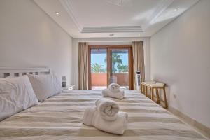 a bedroom with a large bed with towels on it at Mar Azul by La Maison Marbella Rentals in Estepona +26 photos