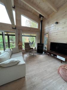 ein Wohnzimmer mit einem Sofa und einem Flachbild-TV in der Unterkunft le vénÉrable in LʼAnse-Saint-Jean