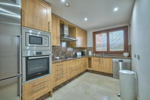 a kitchen with wooden cabinets and stainless steel appliances at Mar Azul by La Maison Marbella Rentals in Estepona