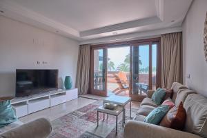 a living room with a couch and a flat screen tv at Mar Azul by La Maison Marbella Rentals in Estepona