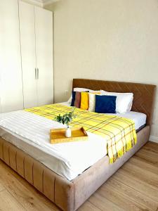 ein Schlafzimmer mit einem großen Bett und einem Tablett darauf in der Unterkunft Евродвушка вблизи MegaSilkWay & EXPO in Prigorodnyy + 3 Fotos