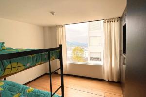 ein Schlafzimmer mit einem Etagenbett und einem großen Fenster in der Unterkunft Av santander apartamento perfecta ubicación in Manizales