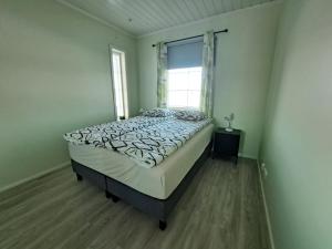 a bedroom with a bed in a room with a window at ALEX - bright, stylish apartment with sauna, built in 2023 in Närpiö