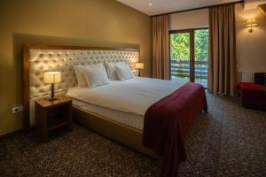 una camera d'albergo con un grande letto e una finestra di Opus Villa a Sinaia