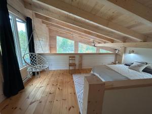 ein Schlafzimmer mit einem Bett in einem Zimmer mit Holzböden in der Unterkunft le vénÉrable in LʼAnse-Saint-Jean