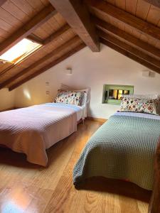 two beds in a room with wooden floors at Casa da Linha in Amarante