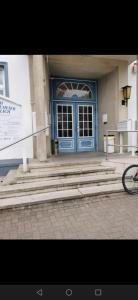 a blue door of a building with stairs in front of it at Ferienwohnung 309 am Kasinopark in Georgsmarienhütte
