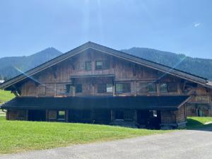 una gran casa de madera en una colina con césped verde en Chalet Neuf, Morgins, en Morgins