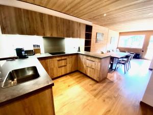 a kitchen with a sink and a table with chairs at Chalet Neuf, Morgins in Morgins