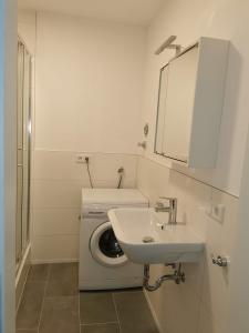 a white bathroom with a washing machine and a sink at Ferienwohnung 309 am Kasinopark in Georgsmarienhütte
