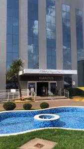 a building with a large swimming pool in front of it at Apartamento 1411 Barretos Park Hotel - O Hotel do Parque do Peão in Barretos