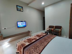 a bedroom with a bed and a tv on the wall at HOTEL NIMBA INTERNATIONAL in Rānībennur