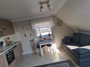 a small kitchen with a table and a couch at Ferienwohnung Petersen in Nordstrand
