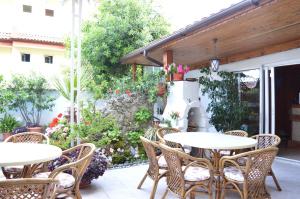 a patio with tables and chairs in a garden at Family Hotel Sofi in Sozopol