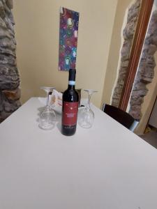 een fles wijn zittend op een tafel met twee glazen bij Cilento Paradise - Appartamento con terrazzo in Marina di Pisciotta in Pisciotta