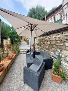 een patio met een parasol, banken en planten bij Cilento Paradise - Appartamento con terrazzo in Marina di Pisciotta in Pisciotta