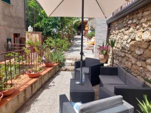 een patio met banken en een parasol bij Cilento Paradise - Appartamento con terrazzo in Marina di Pisciotta in Pisciotta