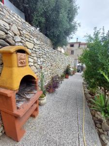a stone wall with a oven next to a sidewalk at Cilento Paradise - Appartamento con terrazzo in Marina di Pisciotta in Pisciotta