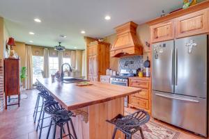 a kitchen with a stainless steel refrigerator and wooden cabinets at Peaceful Haynesville Vacation Rental with Yard! 