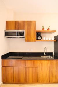 a kitchen with a sink and a microwave at Akbal Tulum in Tulum
