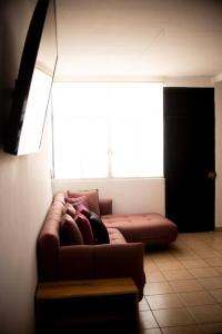 un sofá en una sala de estar con una gran ventana en Casa Vale, en La Paz
