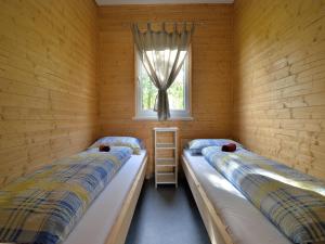 two beds in a room with a window at Meridia - Sventoji in Šventoji