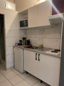 a white kitchen with a sink and a microwave at Petit duplex gare Saint-Roch in Montpellier
